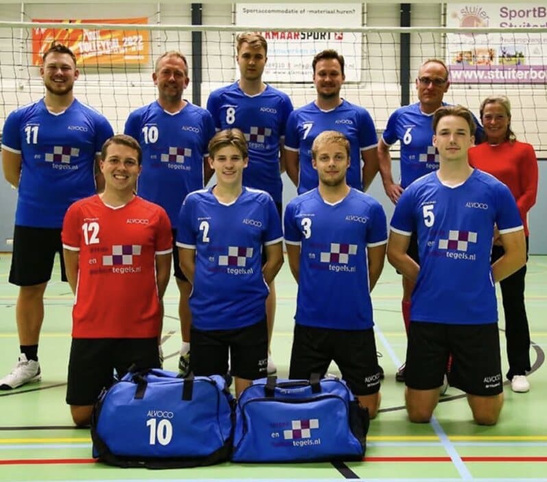 Het eerste herenteam van volleybalvereniging Alvoco in de sporthal, met ons logo op de shirts en op de tassen