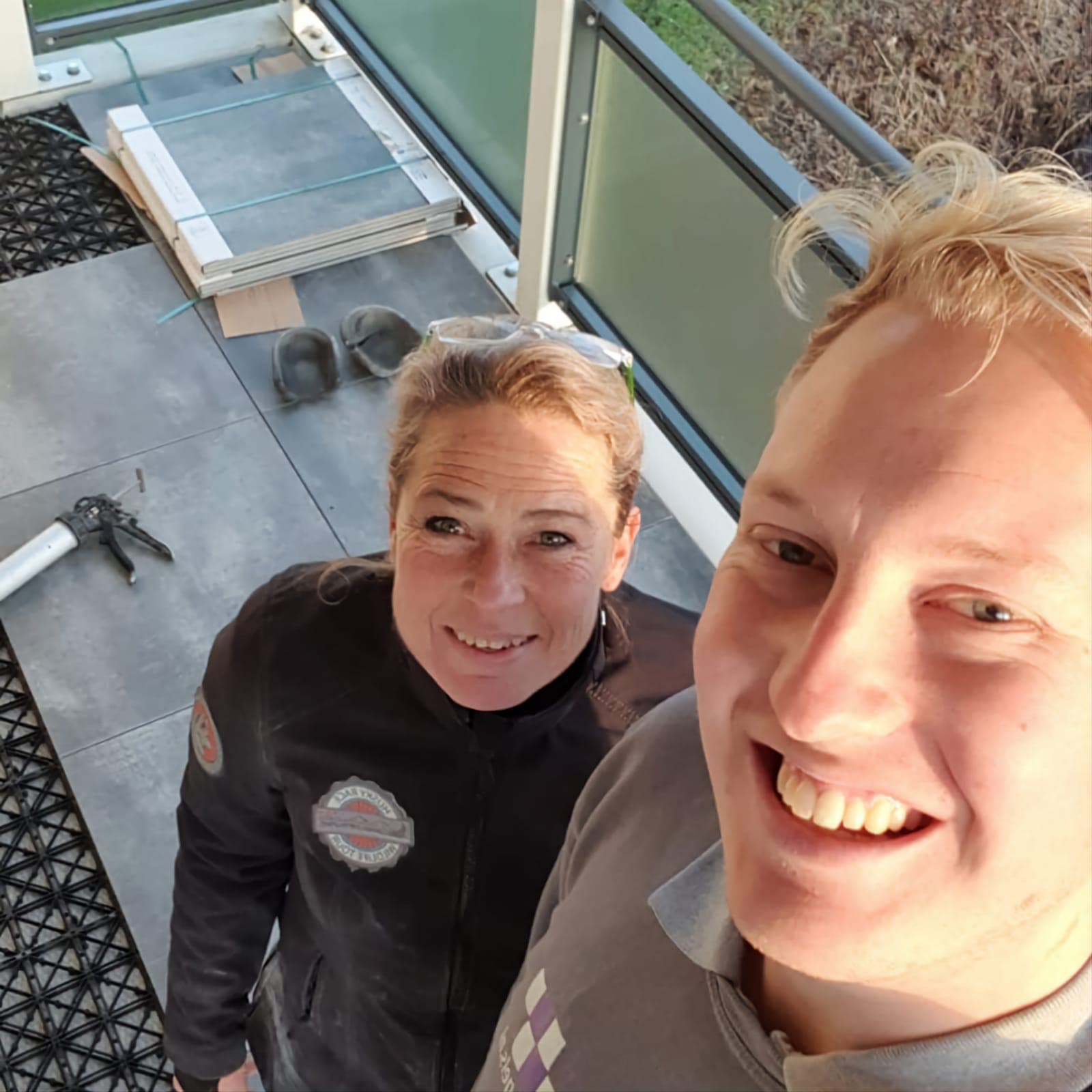 Mariska Leeuw met een collega op een balkon waar tegels worden gelegd