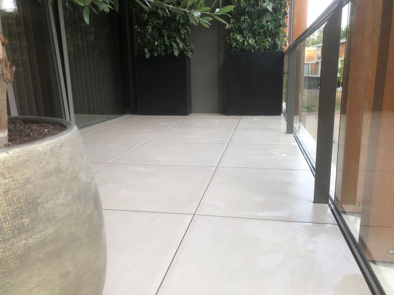 Project Den Haag Duinvallei: Licht balkon met grote beige tegels en een glazen balustrade
